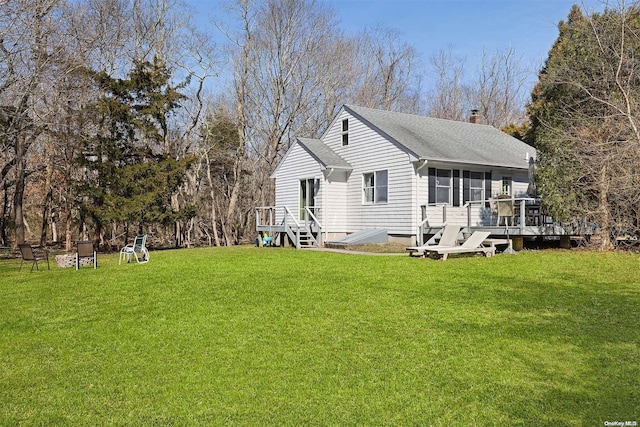 rear view of property with a lawn and a deck