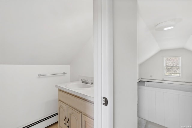 bathroom featuring vanity, vaulted ceiling, and a baseboard heating unit