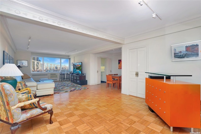 living room with radiator heating unit, rail lighting, light parquet floors, and ornamental molding