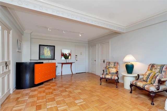 living area with crown molding, light parquet flooring, and track lighting