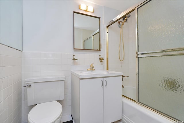 full bathroom with vanity, toilet, shower / bath combination with glass door, and tile walls