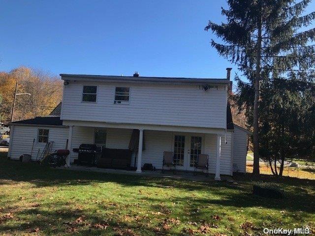 back of house with french doors and a yard