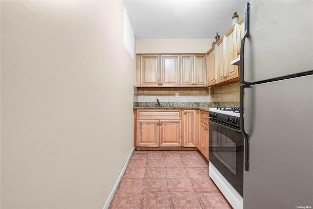 kitchen featuring decorative backsplash, dark stone counters, white appliances, sink, and light tile patterned floors