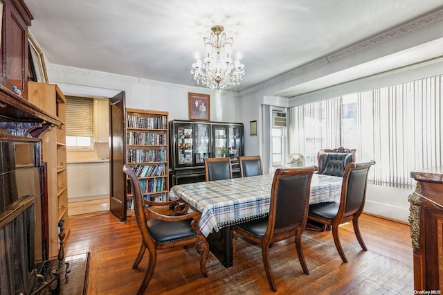 dining area featuring a chandelier, dark wood-type flooring, and ornamental molding