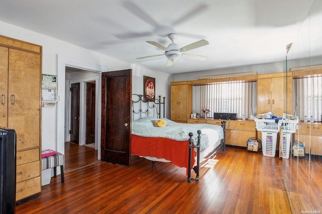 bedroom with dark hardwood / wood-style floors and ceiling fan