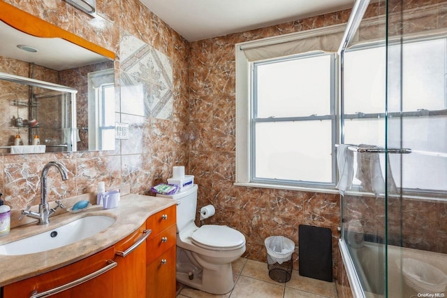 full bathroom with shower / bath combination with glass door, tile patterned flooring, vanity, and tile walls