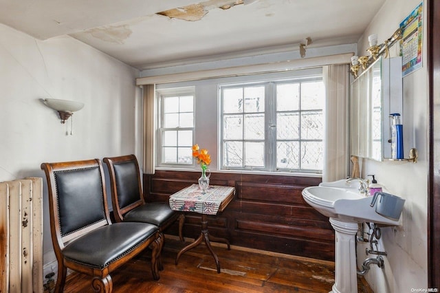 sitting room with dark hardwood / wood-style floors and wood walls