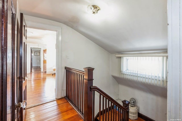 corridor with lofted ceiling and light hardwood / wood-style flooring