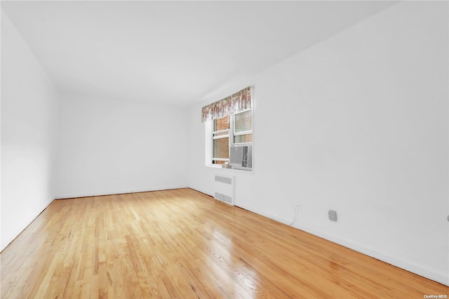 empty room featuring hardwood / wood-style floors and radiator