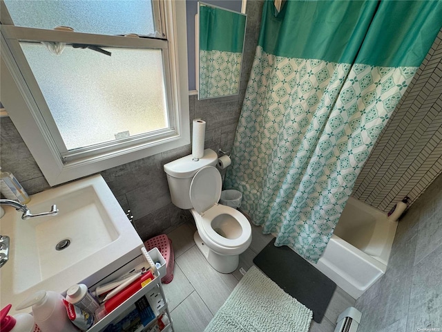 full bathroom with a baseboard heating unit, tile patterned floors, tile walls, toilet, and shower / tub combo