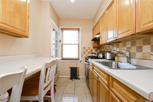 kitchen with decorative backsplash, sink, and stainless steel gas range