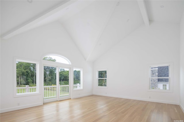 unfurnished living room with light hardwood / wood-style floors, beam ceiling, and high vaulted ceiling