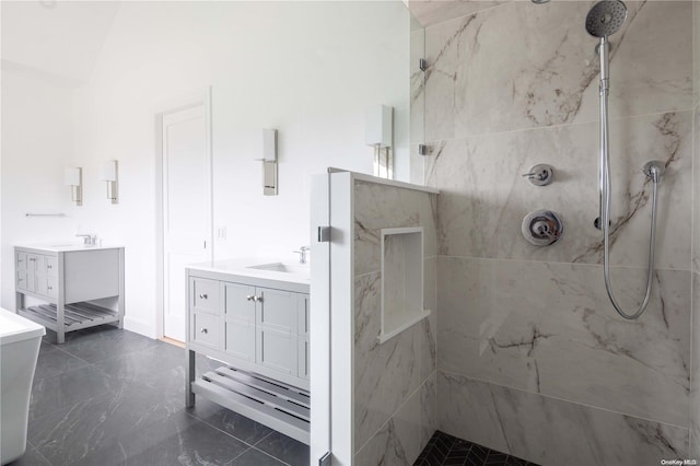 bathroom featuring a tile shower and vanity