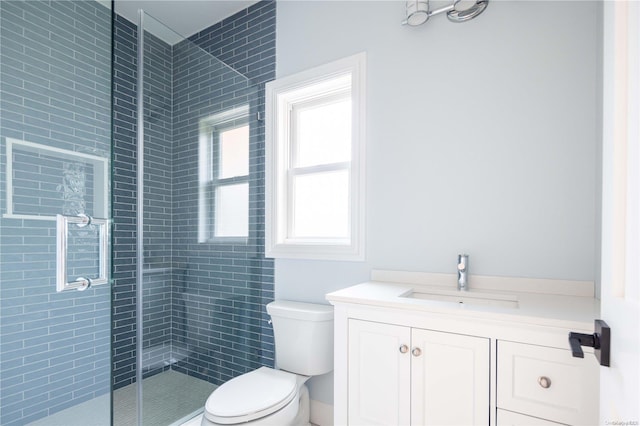 bathroom featuring vanity, toilet, and a shower with door