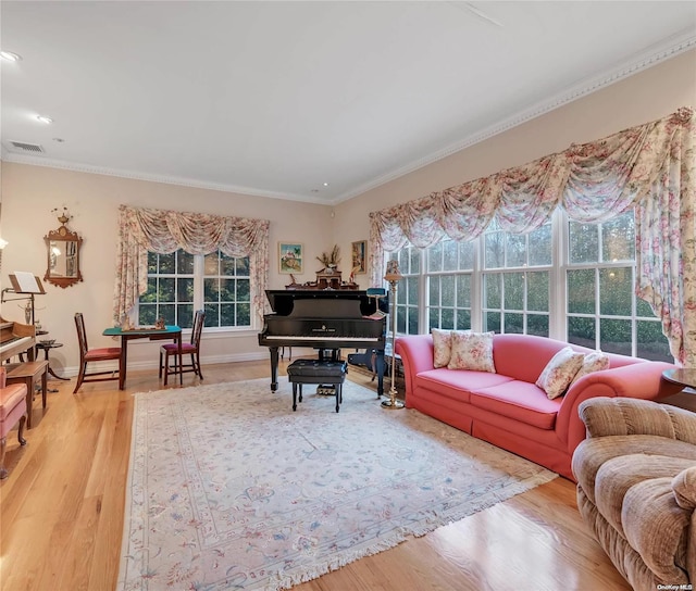 living room with wood-type flooring, a wealth of natural light, and crown molding