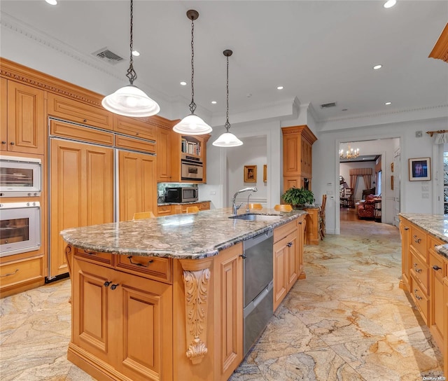 kitchen with built in appliances, sink, a kitchen island with sink, and hanging light fixtures