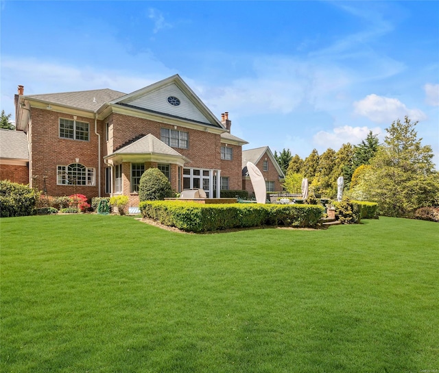 rear view of house featuring a yard