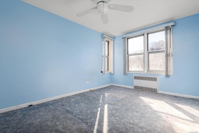 spare room featuring radiator, ceiling fan, and carpet