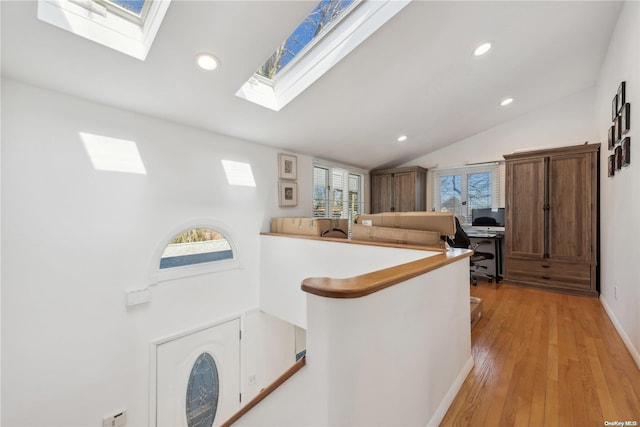 kitchen featuring lofted ceiling, kitchen peninsula, and light hardwood / wood-style flooring