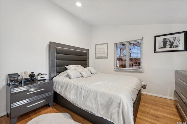 bedroom featuring hardwood / wood-style flooring and vaulted ceiling