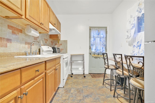 kitchen featuring white range, tasteful backsplash, and sink