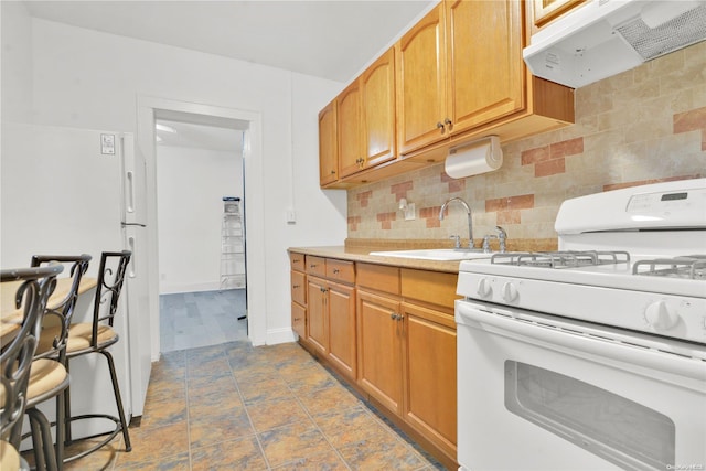 kitchen with sink, backsplash, white gas range, and exhaust hood