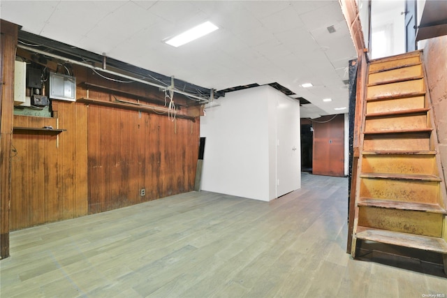 basement featuring wood walls and hardwood / wood-style flooring