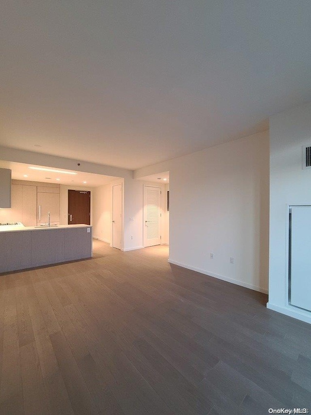 unfurnished living room with dark wood-type flooring