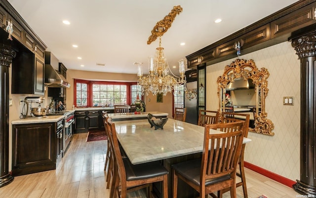 dining space featuring light wood-type flooring and an inviting chandelier