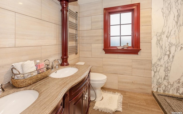 bathroom featuring vanity, wood-type flooring, tile walls, and toilet