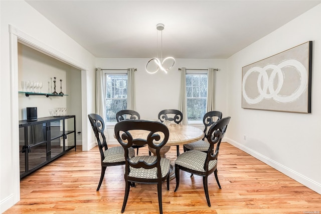 dining area with a chandelier, light hardwood / wood-style floors, and a wealth of natural light