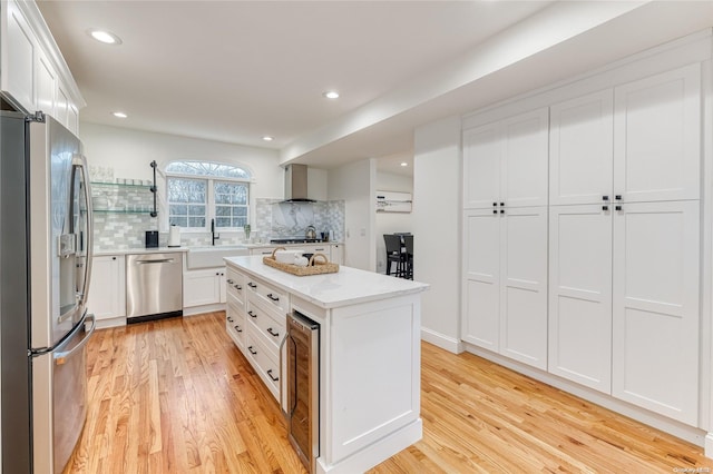 kitchen featuring white cabinetry, a kitchen island, light hardwood / wood-style floors, and appliances with stainless steel finishes