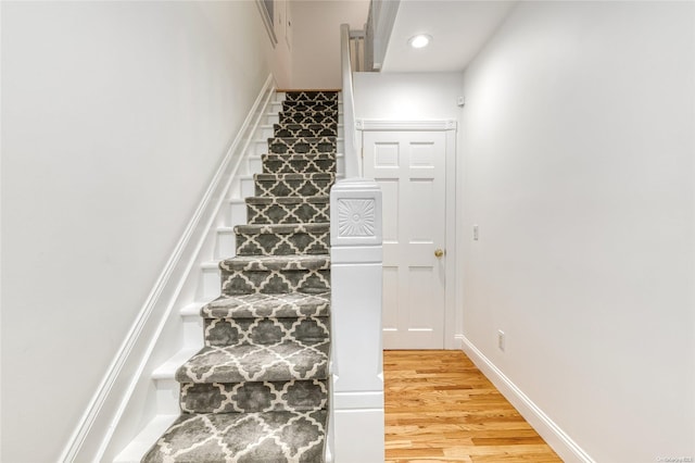 stairway with hardwood / wood-style flooring