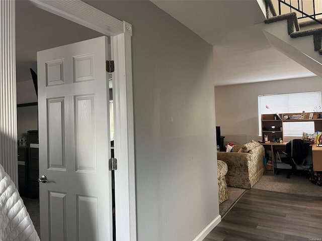 hallway featuring dark wood-style floors, baseboards, and stairway