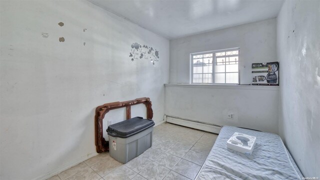 tiled bedroom with a baseboard heating unit