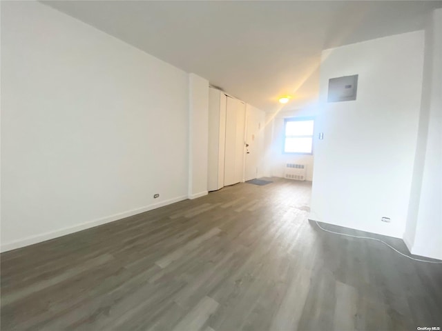 interior space featuring lofted ceiling, dark wood-type flooring, and radiator