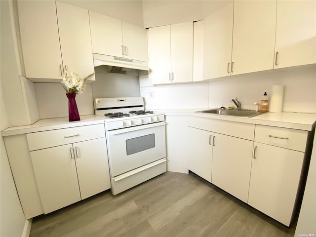 kitchen featuring white gas range oven, white cabinetry, light hardwood / wood-style flooring, and sink