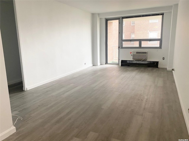 empty room with a wall mounted air conditioner and hardwood / wood-style flooring