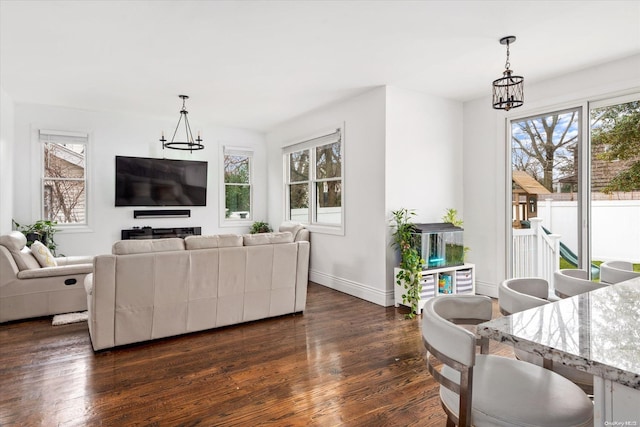 living room featuring dark hardwood / wood-style flooring, an inviting chandelier, and plenty of natural light