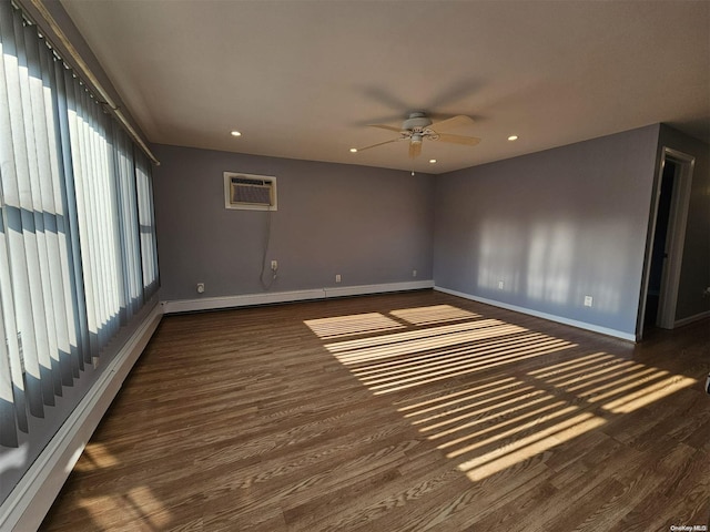 empty room featuring a wall mounted air conditioner, dark hardwood / wood-style flooring, ceiling fan, and a baseboard heating unit