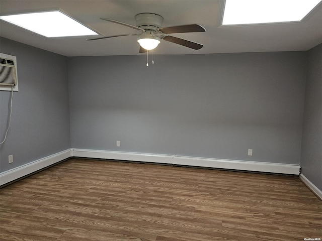 unfurnished room with a wall mounted air conditioner, hardwood / wood-style floors, baseboard heating, and ceiling fan