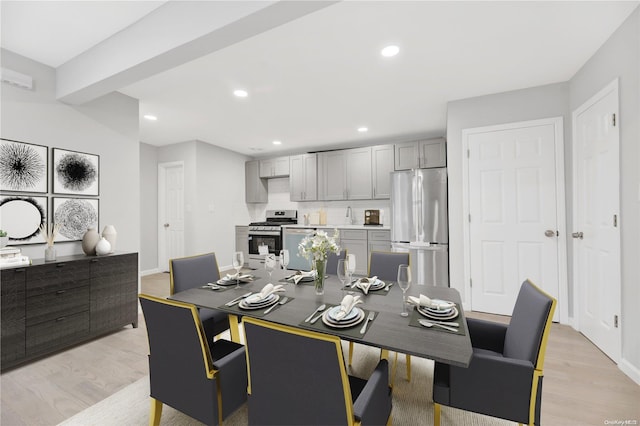 dining space with beam ceiling and light wood-type flooring