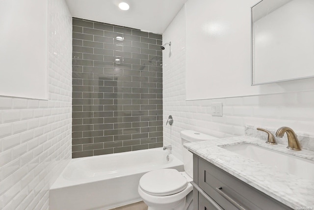 full bathroom featuring vanity, backsplash, tiled shower / bath, toilet, and tile walls