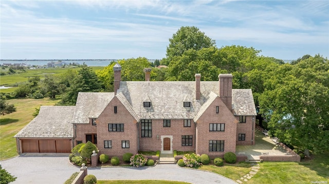 16 Tuthill Ln, Remsenburg, NY 11960 - tudor-style house with a chimney, curved driveway, and an attached garage