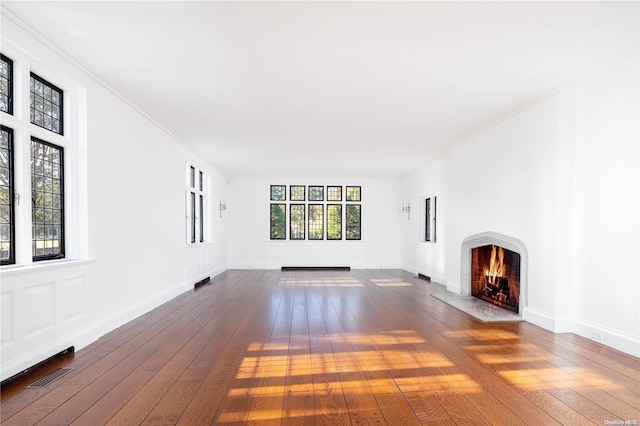 16 Tuthill Ln, Remsenburg, NY 11960 - unfurnished living room featuring a fireplace with flush hearth, hardwood / wood-style flooring, and crown molding