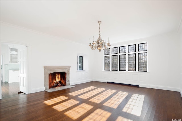 unfurnished living room featuring a chandelier, crown molding, and dark wood-type flooring