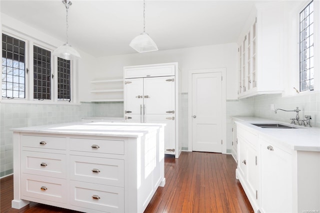 kitchen featuring white cabinetry, sink, and hanging light fixtures