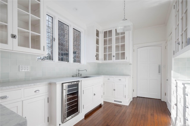 16 Tuthill Ln, Remsenburg, NY 11960 - bar area with wine cooler, dark wood-style floors, backsplash, decorative light fixtures, and ornamental molding