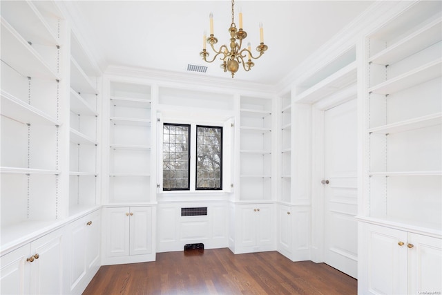 spacious closet with dark hardwood / wood-style floors and a chandelier