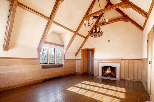 unfurnished living room featuring hardwood / wood-style floors, high vaulted ceiling, wood walls, and beam ceiling